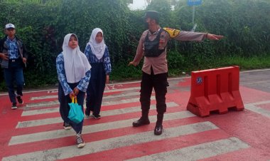 Bhabinkamtibmas Desa Citapen Polsek Ciawi Polres Bogor Bripka M. Obay Wijaya Melaksanakan Gatur Lalin Membantu Menyebrangkan Anak-Anak Sekolah